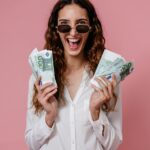 woman in white button up shirt holding money