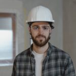 man in black and white plaid button up shirt wearing white hard hat