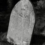 grayscale photo of concrete tombstone